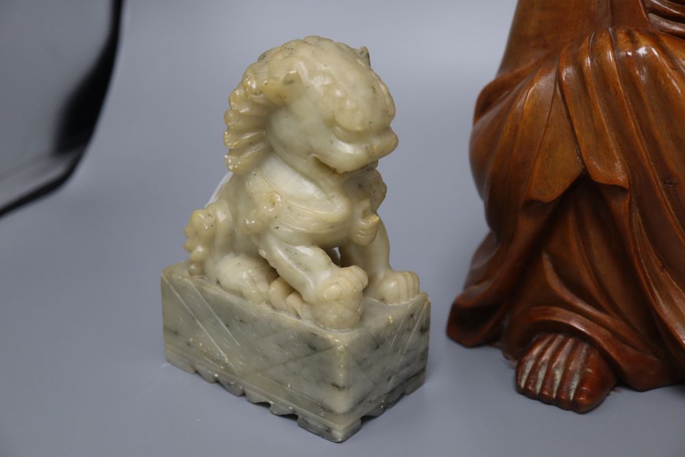 A Japanese rootwood carving of a seated elder, inset eyes and teeth and a pair of Chinese soapstone shishi, each crouched on a rectangu